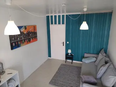 a living room with a couch and a green wall at Comfort in the Downtown in Porto