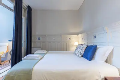 a bedroom with a large white bed with blue pillows at APorTo - 2 Suites in Porto