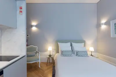 a bedroom with a large white bed with blue pillows at Villa Mouzinho by ON Apartments in Porto