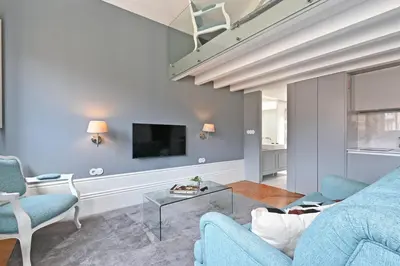 a living room with a blue couch and a tv at Villa Mouzinho by ON Apartments in Porto