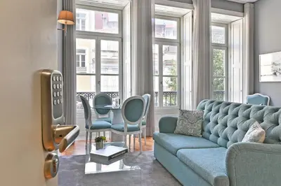 a living room with a blue couch and chairs at Villa Mouzinho by ON Apartments in Porto