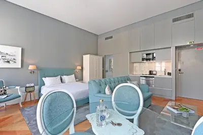 a hotel room with a bed and a couch and chairs at Villa Mouzinho by ON Apartments in Porto