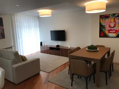 a living room with a table and a television at Lux Bolhão - ALL INCLUDED in Porto