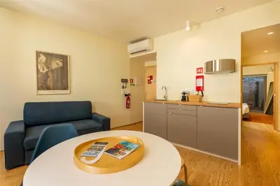 a living room with a table and a kitchen at Feel Porto Codeçal Apartments in Porto