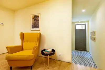a living room with a yellow chair and a table at Feel Porto Codeçal Apartments in Porto
