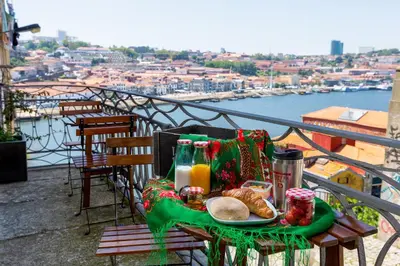 a table with a plate of food on a balcony at Feel Porto Codeçal Apartments in Porto