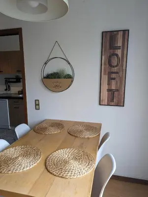 a wooden table with chairs and a sign on a wall at Pine Tree Apartment in Porto