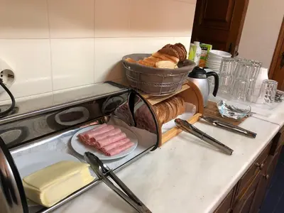 a counter top with a plate of bread and a basket of meat at Origami Porto Residência & Hostel in Vila Nova de Gaia