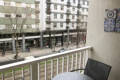 a balcony with a chair and a view of a building at Origami Porto Residência & Hostel in Vila Nova de Gaia