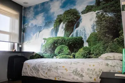 a bedroom with a waterfall mural on the wall at Amazing Amial in Porto