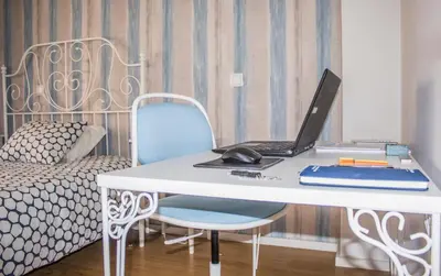 a laptop computer sitting on a white desk with a bed at Amazing Amial in Porto