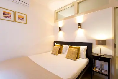 a bedroom with a white bed with yellow pillows at Home @ Porto Clérigos Apartment in Porto