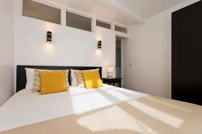 a bedroom with a large bed with yellow pillows at Home @ Porto Clérigos Apartment in Porto