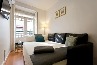 a living room with a couch and a window at Home @ Porto Clérigos Apartment in Porto