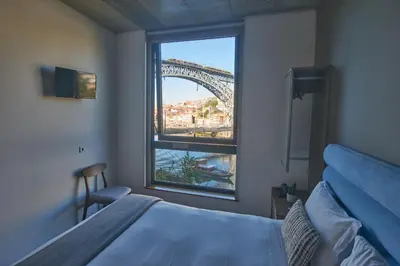 a bedroom with a bed and a view of the eiffel tower at Bridge It - Suites & Views in Vila Nova de Gaia