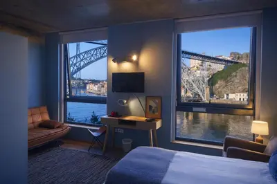 a hotel room with a bed and a view of a bridge at Bridge It - Suites & Views in Vila Nova de Gaia