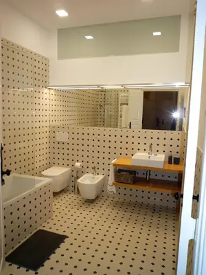 a bathroom with two toilets and a sink and a mirror at Casa Familiar do Porto in Porto