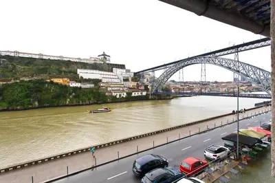 a bridge over a river with cars parked on a highway at RVA - Gustave Eiffel Apartments in Porto