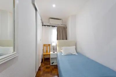 a bedroom with a bed with a blue bedspread at Braganca Oporto in Porto