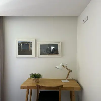 a desk in a room with a lamp and pictures on the wall at bnapartments Palacio in Porto