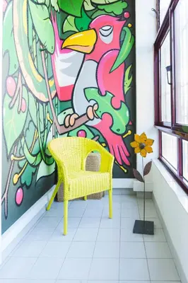 a yellow chair in front of a colorful wall at APOSENTUS - Your Home in Martires da Liberdade in Porto