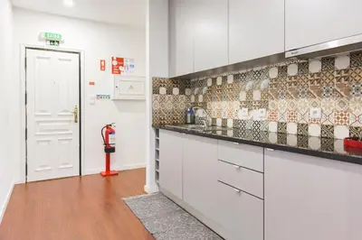 a kitchen with white cabinets and a tile wall at APOSENTUS - Your Home in Martires da Liberdade in Porto