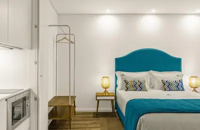 a bed with a blue headboard in a room at 296 Heritage Apartments in Vila Nova de Gaia