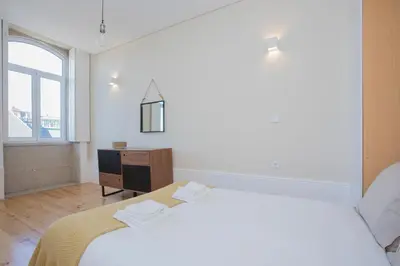 a bedroom with a bed and a dresser and a window at Liiiving In Porto | Bolhão Market Apartments in Porto