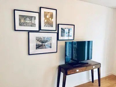 a tv on a table with pictures on a wall at Oporto Chic&Cozy - S. Bento in Porto