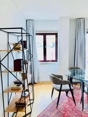 a living room with a glass table and a chair at Oporto Chic&Cozy - S. Bento in Porto