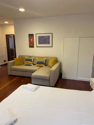 a living room with a couch and yellow pillows at Sao Bento Studio in Porto