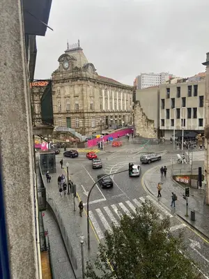 a busy city street with cars and a clock tower at Sao Bento Studio in Porto