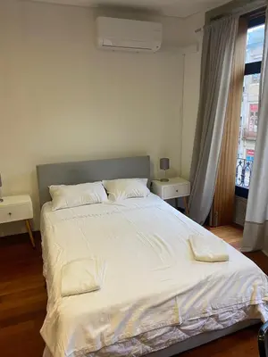 a bedroom with a large bed with white sheets and pillows at Sao Bento Studio in Porto