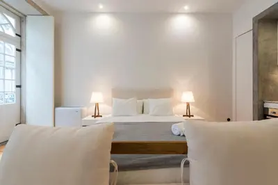 a white bedroom with a bed and two lamps at LovelyStay - Rico's Apartment - Almada 1ºF in Porto