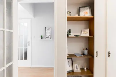 a door leading into a room with white walls and wooden shelves at Gaia Metro-2 Bedrooms in Vila Nova de Gaia