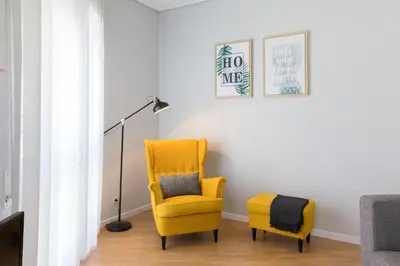 a yellow chair in a living room with a lamp at Gaia Metro-2 Bedrooms in Vila Nova de Gaia