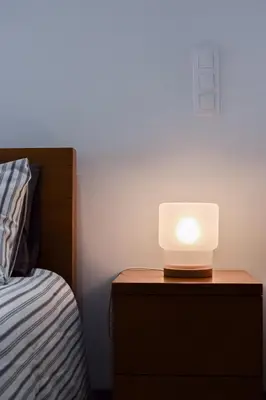 a light on a night stand next to a bed at Aurora Street in Porto