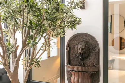 a mirror with a bust of a lion next to a tree at ALQUIMIA DOS ALIADOS - Gorgeous Palace Apartment in Porto
