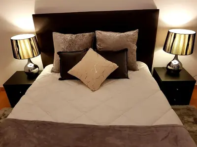 a bedroom with a bed with pillows and two lamps at Oporto Cozy Studio in Porto