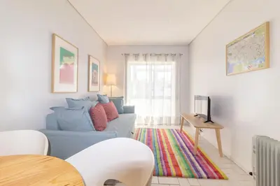 a living room with a blue couch and a tv at Cedofeita 408, Green in Porto