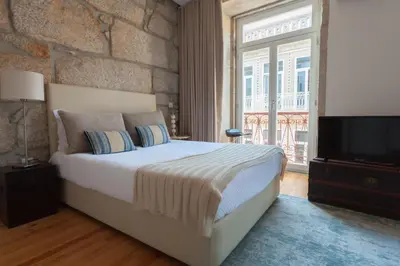 a bedroom with a large bed and a tv at Oporto City View - Santo Ildefonso Lovely in Porto