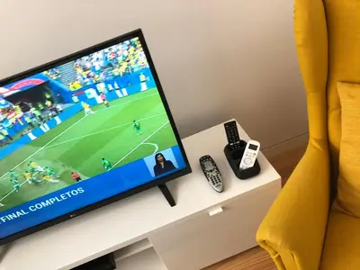 a television sitting on a table with a remote control at Urban Views Townhouse Arrábida in Porto