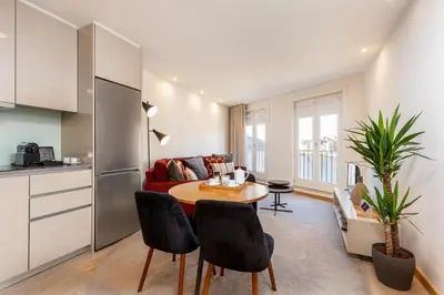a kitchen and a living room with a table and chairs at YOUROPO - Ribeira Gaia in Vila Nova de Gaia