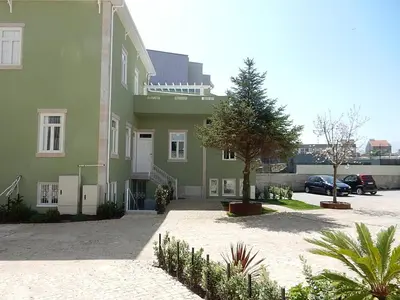 a green building with a car parked in a parking lot at Porto Traveler Apartment in Porto