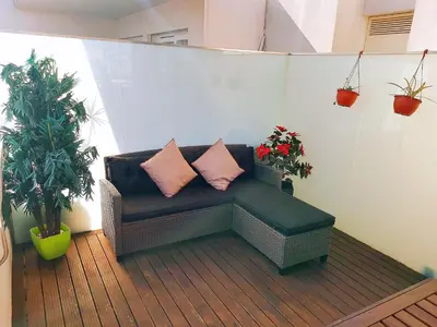 a couch with two pillows on a balcony with plants at Unique Penthouse Porto near Livaria Lello - 40m2 Terrace and Free Parking in Porto