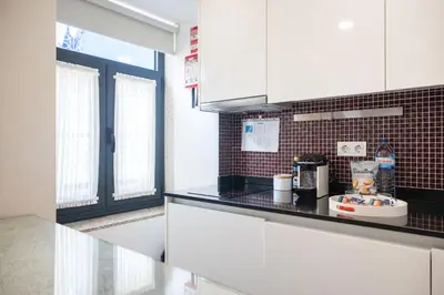 a kitchen with white cabinets and a black counter top at Central Luxury apartment w AC Downtown and Metro in Porto