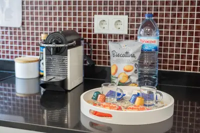 a counter with a tray of drinks and a bottle of water at Central Luxury apartment w AC Downtown and Metro in Porto