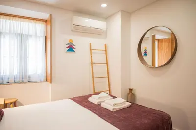 a bedroom with a bed with a mirror and towels at Central Luxury apartment w AC Downtown and Metro in Porto
