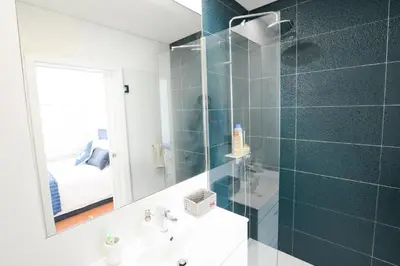 a bathroom with a shower and a sink and a mirror at LUXURY Golden River Apartment - In the Heart of city center and wine cellars in Vila Nova de Gaia