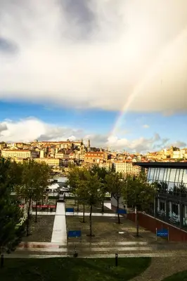 a rainbow in the sky over a city with buildings at LUXURY Golden River Apartment - In the Heart of city center and wine cellars in Vila Nova de Gaia